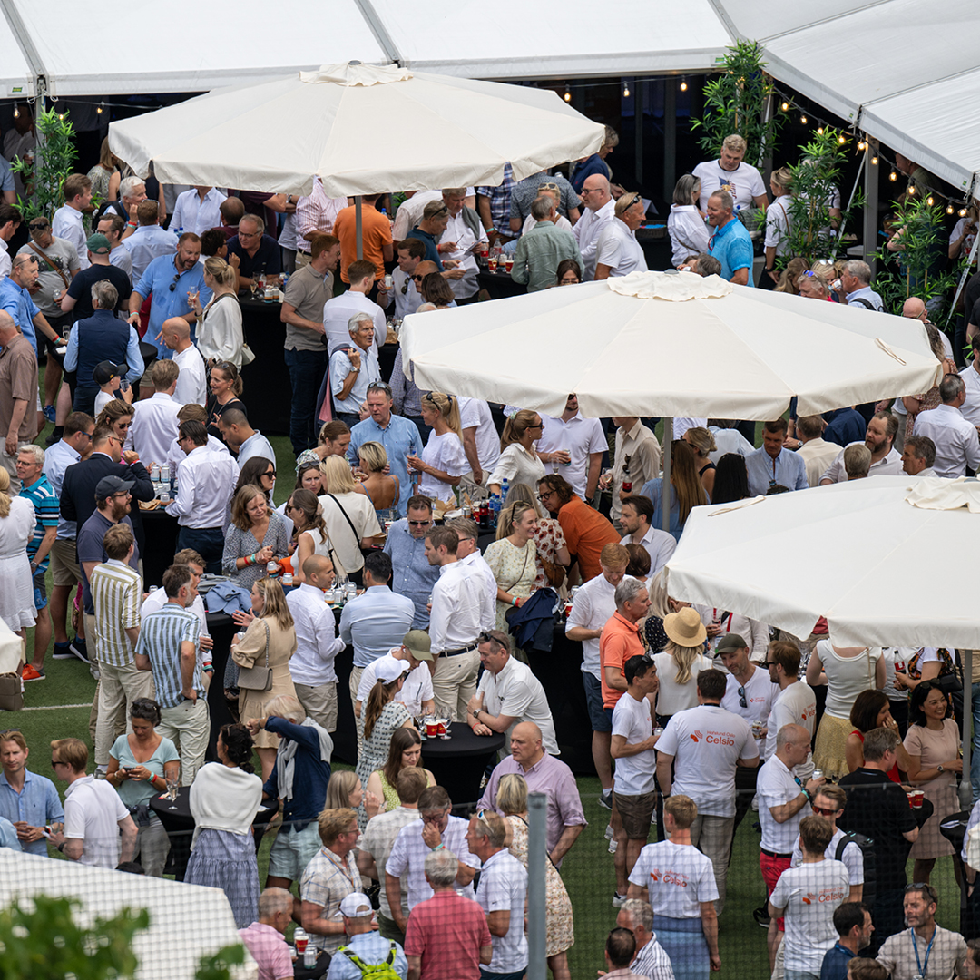Festivalgjester samles under store parasoller på utendørsarrangement – Medvind Eventbyrå